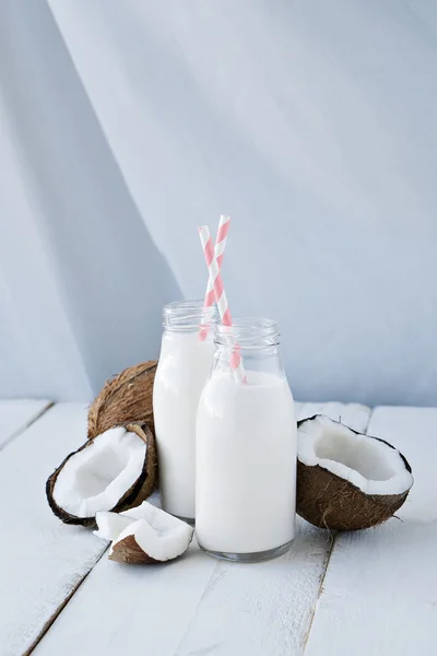 Noix de coco avec lait de coco sur table en bois — Photo