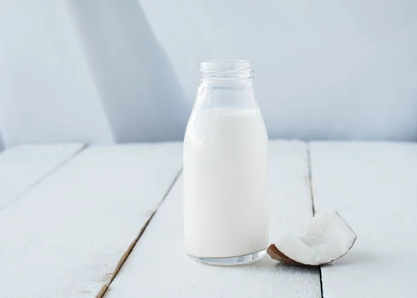 Coco com leite de coco na mesa de madeira — Fotografia de Stock