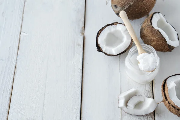 Kokosnoten met kokosolie op witte tafel — Stockfoto