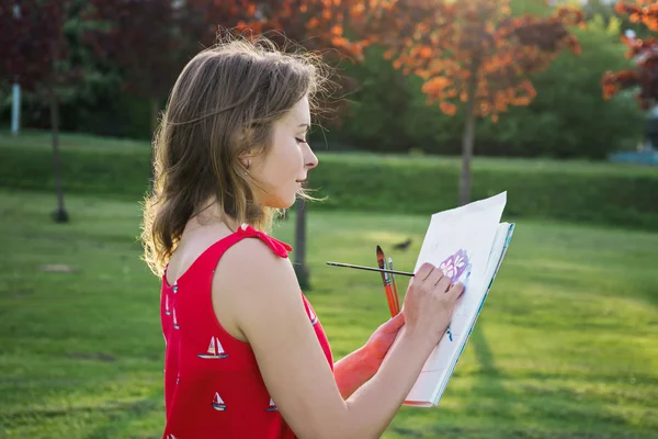 Mooie jonge vrouw buiten schilderen — Stockfoto