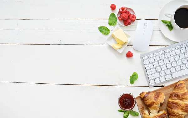 Croissants and coffee at workplace — Stock Photo, Image