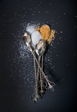 kaşık siyah masada beyaz ve kahverengi şeker