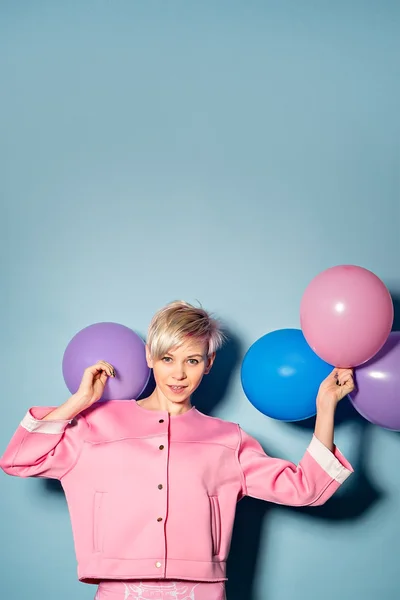 Girl have fun with colored balloons on blue background — Stock Photo, Image