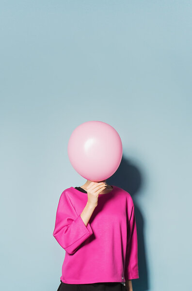 girl have fun with colored balloons on blue background