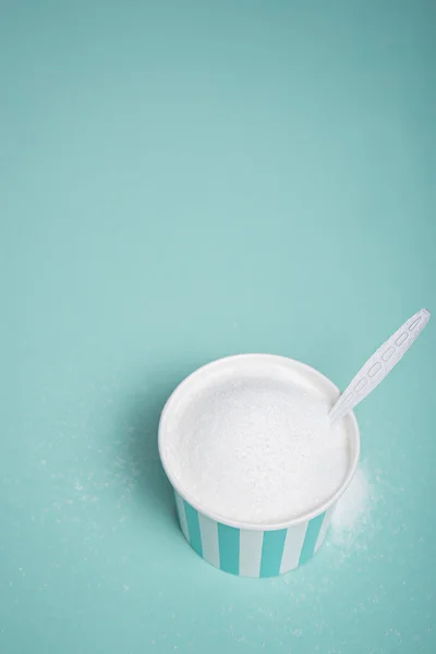 Witte suiker in fel blauwe kom op houten tafel — Stockfoto