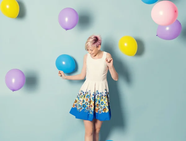 Chica divertirse con globos de colores sobre fondo azul —  Fotos de Stock