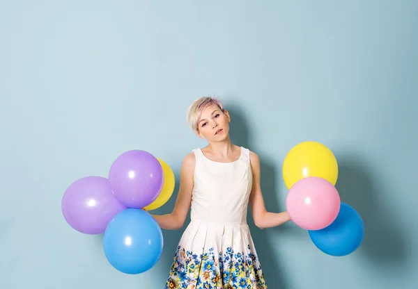 Κορίτσι να διασκεδάσουν με χρωματιστά μπαλόνια σε μπλε φόντο — Φωτογραφία Αρχείου