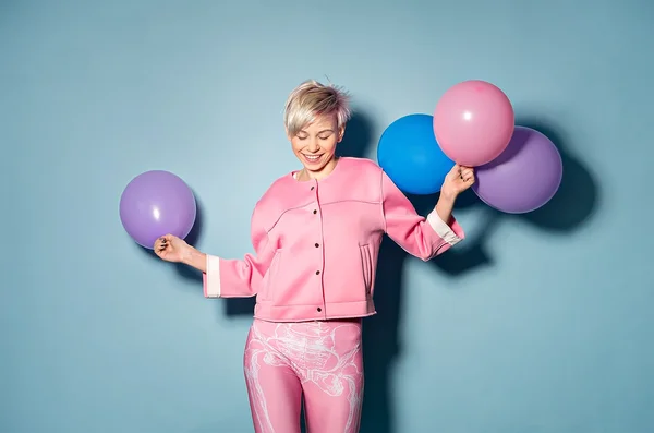 Dziewczyna zabawy z kolorowych balonów na niebieskim tle — Zdjęcie stockowe