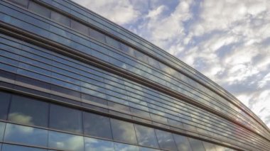 Dusk 4K UHD Zaman Çizelgesi 'ndeki Cam Viraj Binasında Yansıyan Düşük Geniş Açı Bulut Görüntüsü