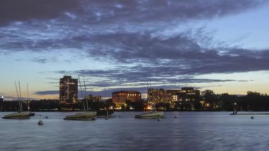 Wide of the Sailboat and Dock of Bde Maka Ska, veya Calhoun Gölü, Alacakaranlık sırasında Güney Minneapolis Skyline 'ın önünde.