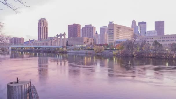 在一个戏剧性的粉色落日4K超高清落日期间 明尼阿波利斯下城和汉内别针大道大桥中的中宽曝光镜头反射出密西西比河 — 图库视频影像