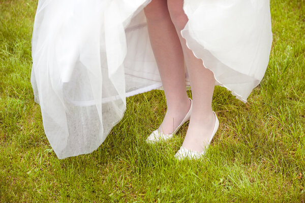 Bride running around on the grass in shoes, detail of wedding shoes