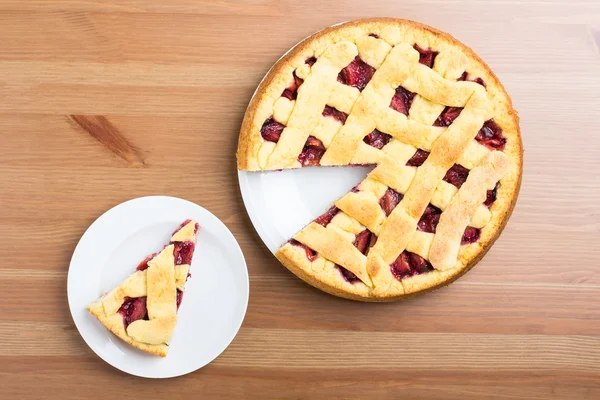 Fresh pie on a plate and table — Stock Photo, Image