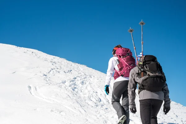 Casal andando em montanhas nevadas — Fotografia de Stock