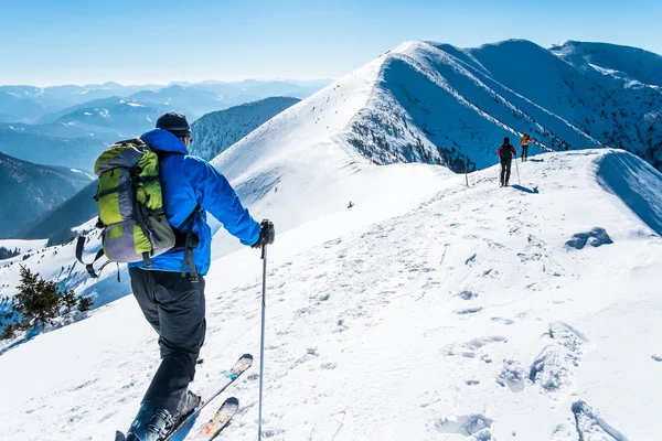 Skialpinists grupo em montanhas nevadas — Fotografia de Stock
