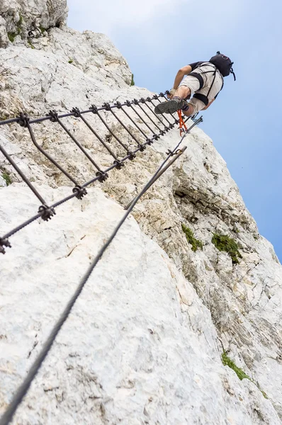 Ferrata - kriechender Mann in den Bergen — Stockfoto