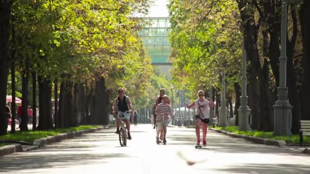 Lidé jezdí na kole, skateboardu, koloběžce v Gorkého parku v létě — Stock video