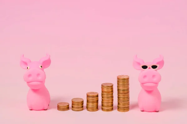 Two pink pigs with coins arranged like steps between them on a pink background. Free copy space.  Minimal creative composition