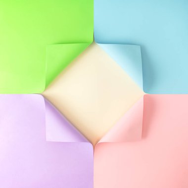 Köşelerde katlanmış renkli kağıtlarla yapılmış yaratıcı bir düzen. Pembe, mavi, mor ve yeşil duvar kağıtları kare ve bedava fotokopi alanı oluşturuyor. Minimum düz konsept.