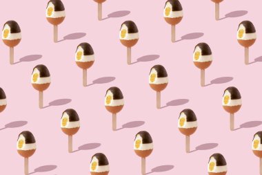 Çubuklu çikolatalı doğal yumurtadan yapılmış yaratıcı desen. Pembe arka planlı ısırık dondurma düzeni. Asgari tatil veya yaz konsepti.