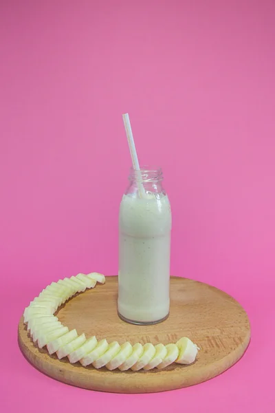 Saboroso smoothie banana no fundo rosa — Fotografia de Stock