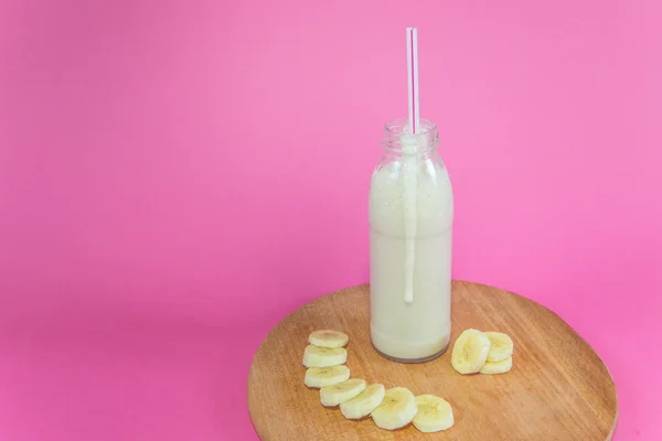 Lekkere banaan smoothie op roze achtergrond — Stockfoto