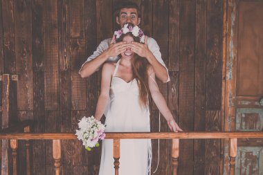 Genç ve güzel gelin ve damat bir iyi ve mutlu zaman birlikte bir düğün photosession Studio rustik süslemeleri ve ahşap arka planlar ile çekim yaparken eğleniyor musun