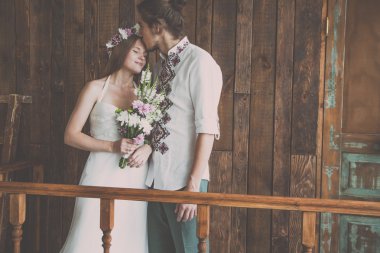 Genç ve güzel gelin ve damat bir iyi ve mutlu zaman birlikte bir düğün photosession Studio rustik süslemeleri ve ahşap arka planlar ile çekim yaparken eğleniyor musun