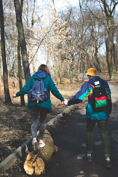 Joven hermosa feliz hipster pareja morena chica y chico tener gran diversión tiempo mientras viaja y caminar en el bosque — Foto de Stock