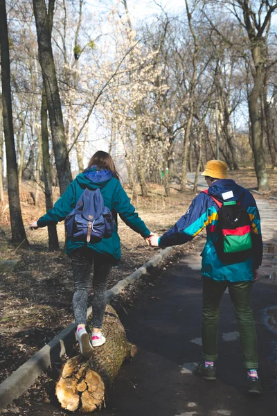 Young beautiful happy hipster couple brunette girl and guy having great fun time while travelling and walking in the woods forest — Stock Photo, Image