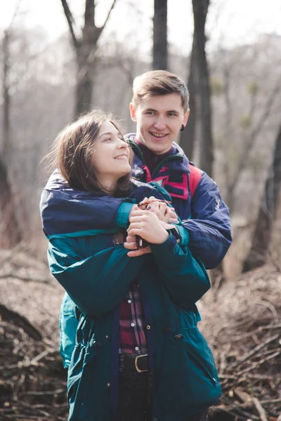 Young beautiful happy hipster couple brunette girl and guy having great fun time while travelling and walking in the woods forest — Stock Photo, Image