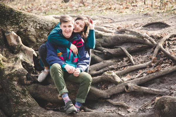 Young beautiful happy hipster couple brunette girl and guy having great fun time while travelling and walking in the woods forest — Stock Photo, Image