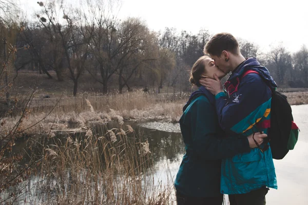 Young beautiful happy hipster couple brunette girl and guy having great fun time while travelling and walking in the woods forest — Stock Photo, Image