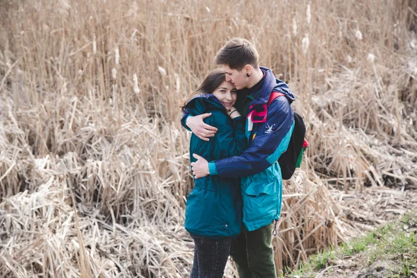 Young beautiful happy hipster couple brunette girl and guy having great fun time while travelling and walking in the woods forest — Stock Photo, Image