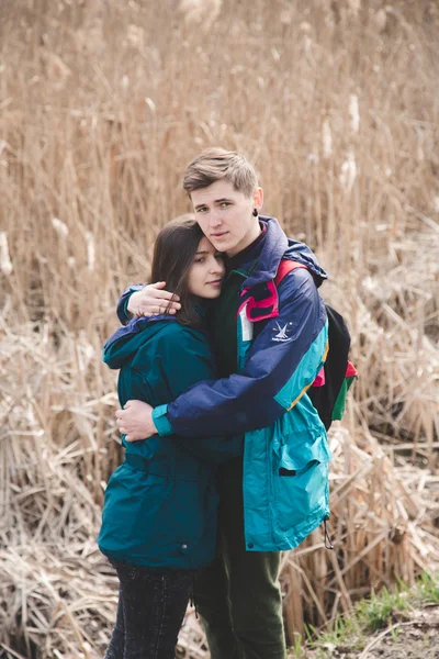 若い美しい幸せな流行に敏感なカップルのブルネットの少女と男が楽しくて時間旅行ながら森の中の森を歩く — ストック写真