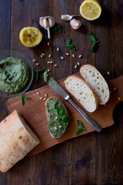 İtalyan pesto hazırlık vegan yorum ezelî parmesan peyniri ile Siyah Zeytin yerine tüm malzemelerin üzerine tablo yeşil fesleğen, sarımsak, limon, çam fıstığı, zeytin hepsi taze ve organik koyu ahşap rustik tarzı tablo arka plan üzerinde siyah