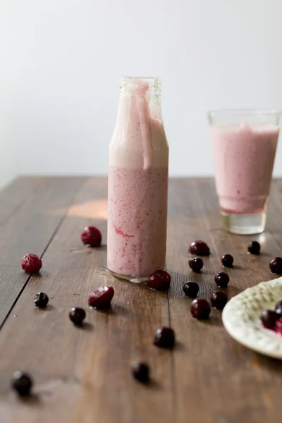 Fresco biologico mora ciliegia frullato fatto di yogurt fatto in casa e bacche dal mercato contadino su sfondo in legno scuro in stile rustico soft focus angolo aereo colpo — Foto Stock