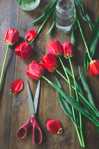 Red fresh cutted tulips on a dark wood rustic background — Stock Photo, Image