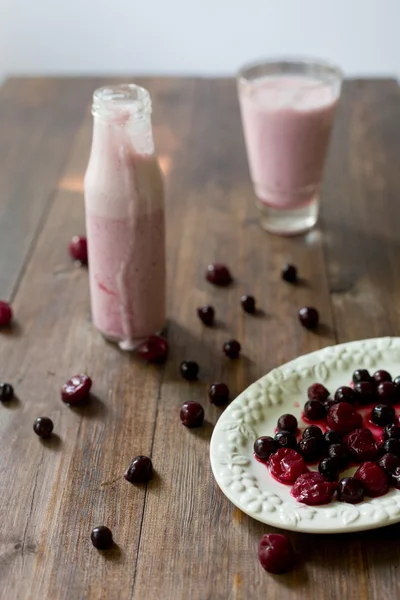 Fresco biologico mora ciliegia frullato fatto di yogurt fatto in casa e bacche dal mercato contadino su sfondo in legno scuro in stile rustico soft focus angolo aereo colpo — Foto Stock