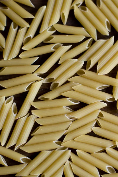 Penne grezze texture modello di sfondo su legno scuro rustico soft focus — Foto Stock