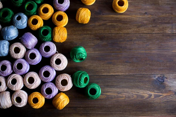 Hilos de hilos para tejer en diferentes colores fondo mesa de madera oscura rústica — Foto de Stock