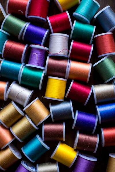 Threads for embroidery and sewing in different colors background soft focus — Stock Photo, Image