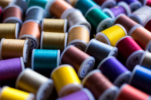 Hilos para bordar y coser en diferentes colores fondo suave enfoque — Foto de Stock