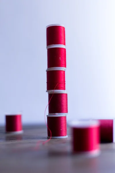 Red threads for embroidery and sewing composition on dark wood table rustic — Stock Photo, Image