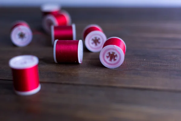 Hilos rojos para bordado y composición de costura sobre mesa de madera oscura rústica —  Fotos de Stock