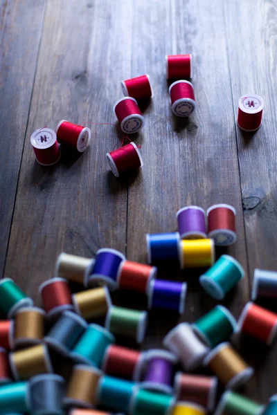 Threads for embroidery and sewing in different colors background soft focus — Stock Photo, Image