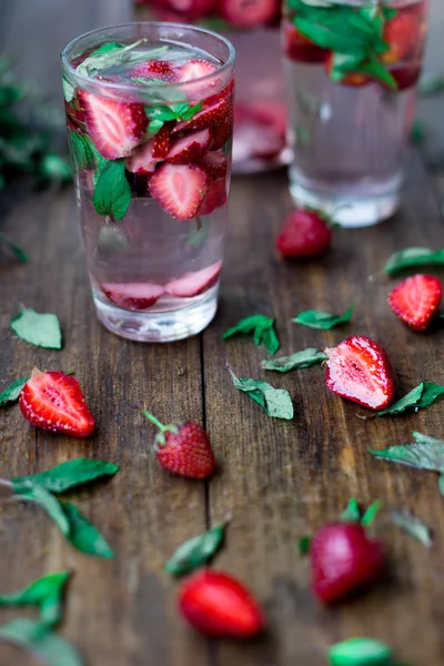 Strawberry mint infused water decorated in rustic style on dark wood table background — Stock Photo, Image