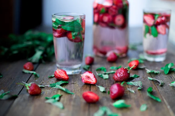 Strawberry mint infused water decorated in rustic style on dark wood table background — Stock Photo, Image