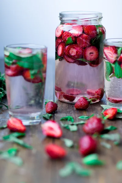 Strawberry mint infused water decorated in rustic style on dark wood table background — Stock Photo, Image