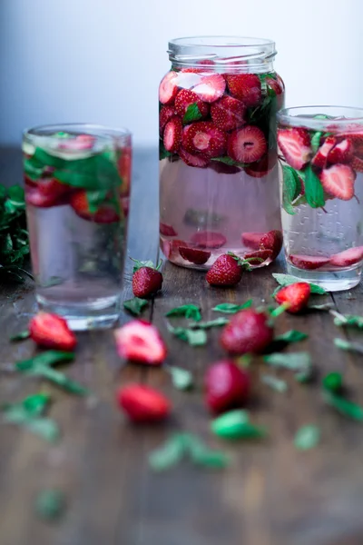 Aardbei munt geïnfundeerd water ingericht in rustieke stijl op donkere houten tafel achtergrond — Stockfoto